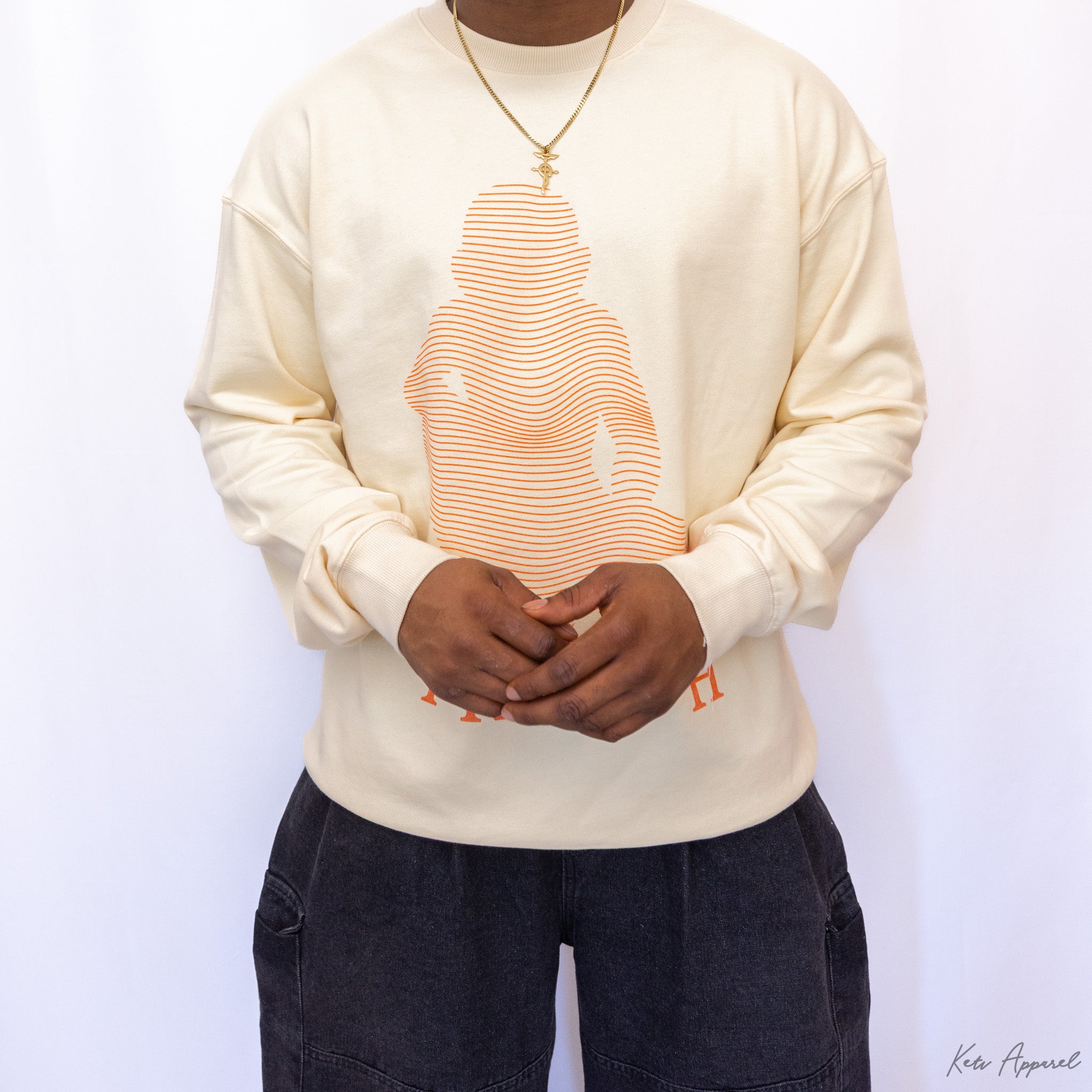 Person wearing a cream sweatshirt with a graphic design on a white background option1_beige