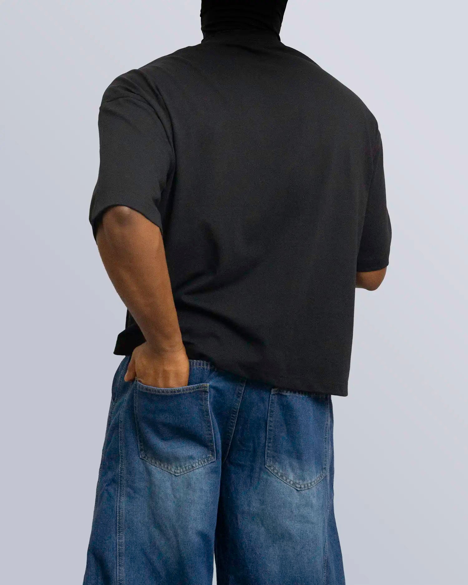 Person wearing a black t-shirt and blue jeans against a plain background option1_black