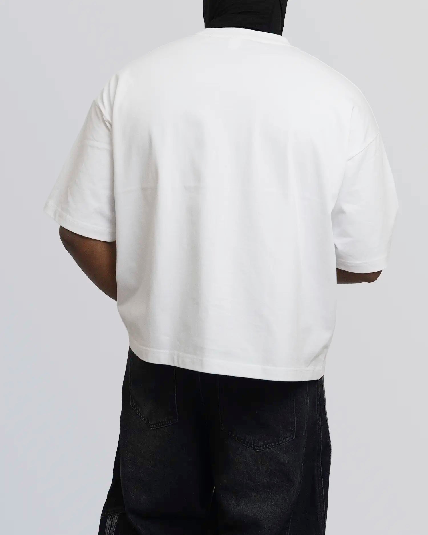 Person wearing a white t-shirt and black pants on a plain background option1_white