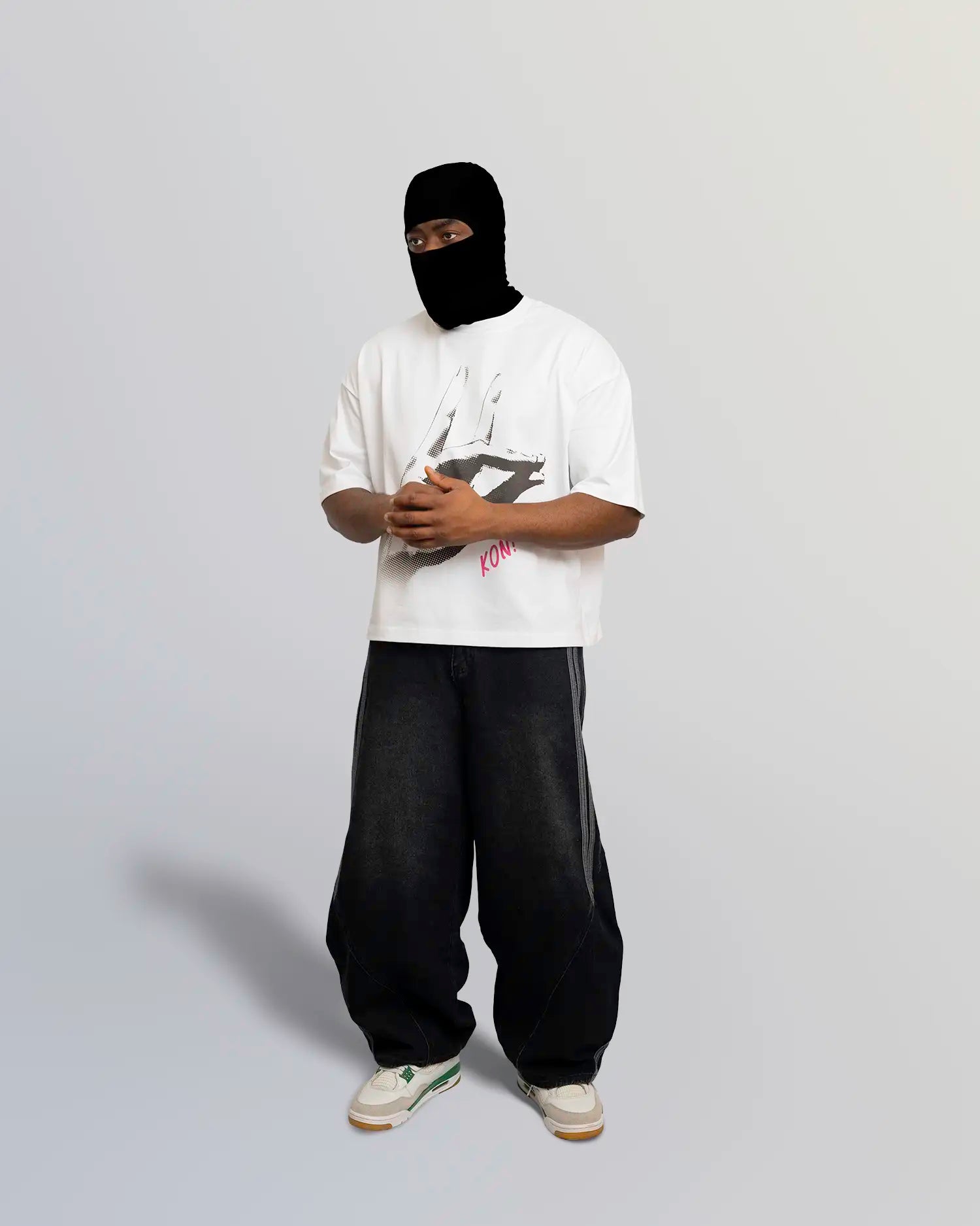 Person wearing a white t-shirt with a logo, black pants, and a black balaclava on a gray background