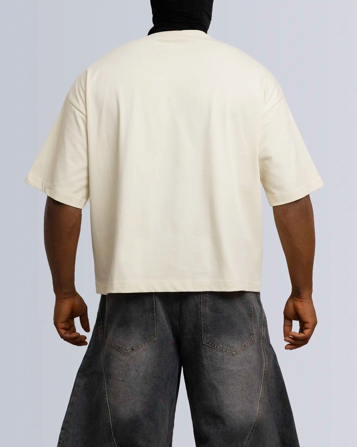 Person wearing a beige t-shirt and dark jeans on a plain background option1_beige